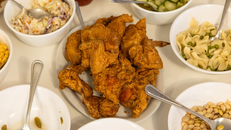 Plate of fried chicken with sides on table