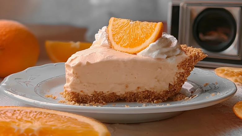 Slice of orange creamsicle pie with orange slice