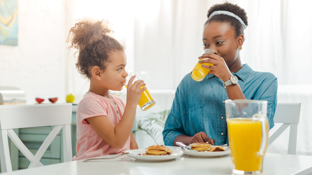 Mom and daughter drinking orange juice