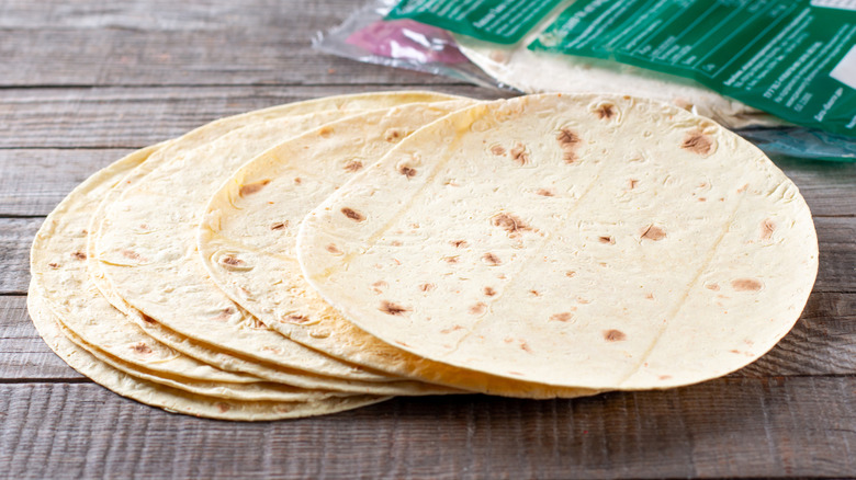 Close-up of flour tortillas on wood surface.