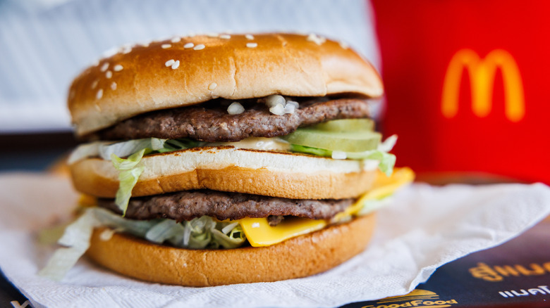 Close-up of McDonald's Big Mac with fries in background.