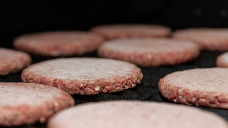 Frozen burger patties on griddle.