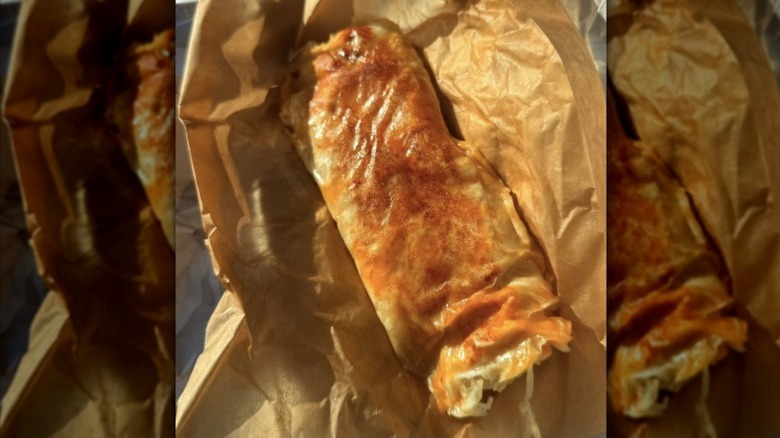 Taco Bell grilled burrito in brown paper wrapper