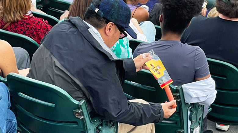  Man taking hot dog out of package
