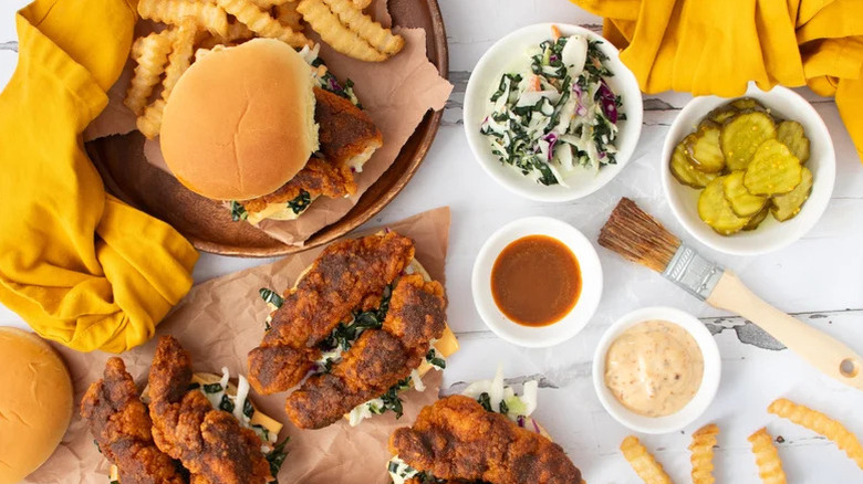 Copycat Dave's Hot Chicken Sandwich on plate surrounded by fried chicken and sauces