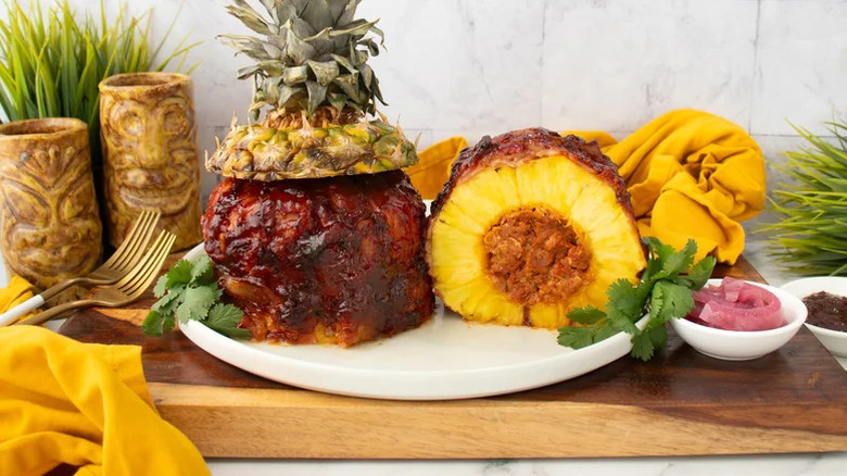Porky-Stuffed Grilled Whole Pineapple sliced in half on plate