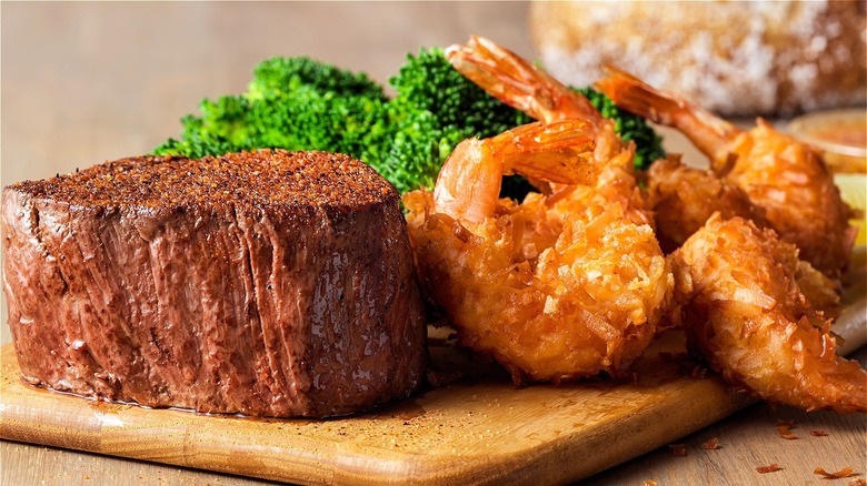 Steak and shrimp on brown wood