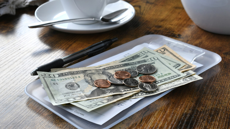 cash paying tab at bar