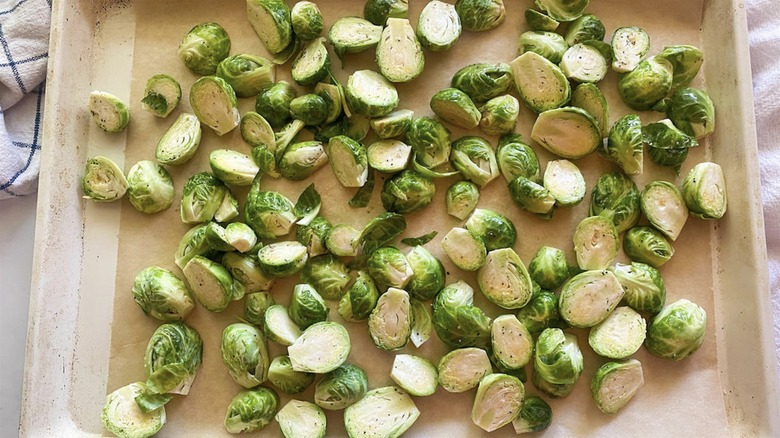 Raw halved Brussels sprouts on a sheet pan