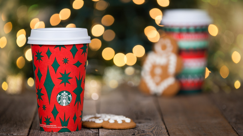 Red Starbucks coffee cup next to a cookie