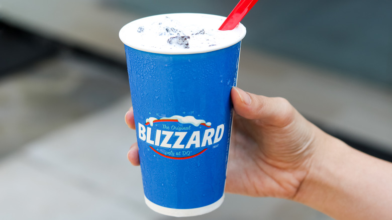 Hand holding a blizzard with red spoon