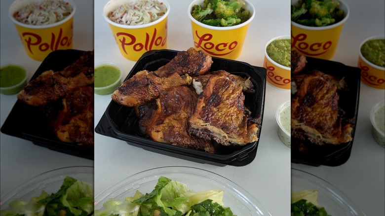 Container of El Pollo Loco chicken surrounded by sides, sauces, and salad.