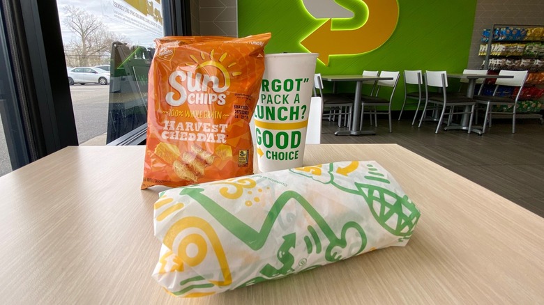 A combo meal from Subway consisting of a sandwich, a drink, and a bag of chips.