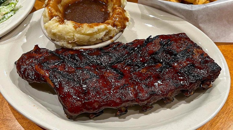 Plate of Texas Roadhouse ribs with side of mashed potatoes and gravy.