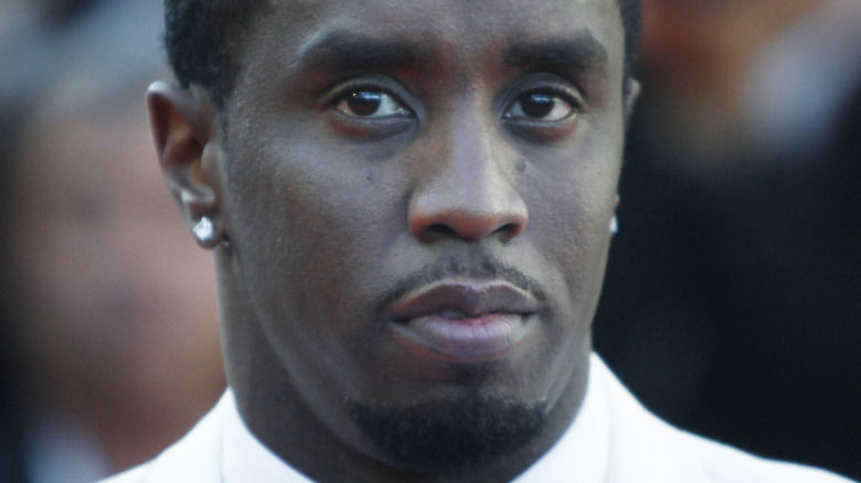 P Diddy in a white tuxedo with serious expression