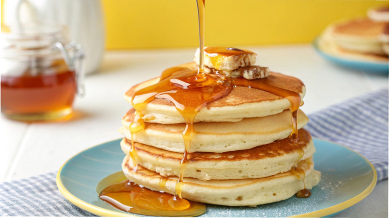 Syrup pouring on pancakes