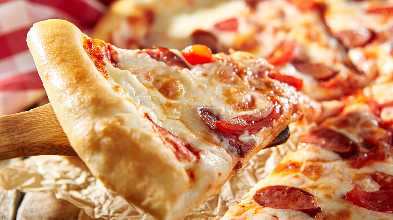 close-up of pizza slice with pepperoni and red peppers