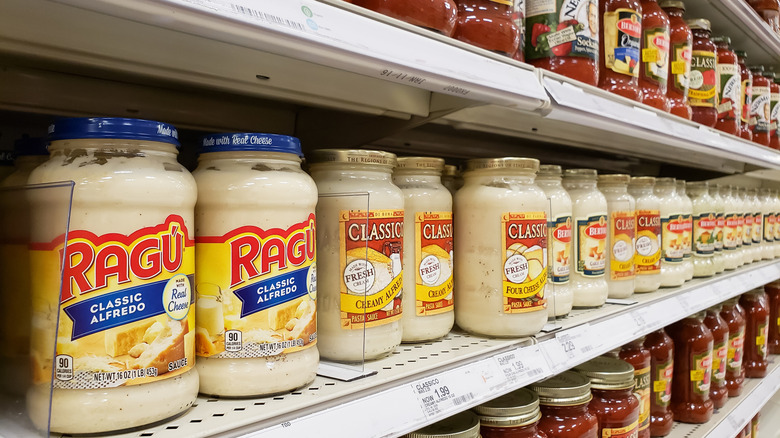 Various types of jarred pasta sauce on shelf