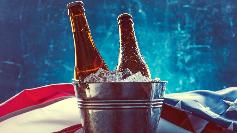 Two beers in an ice bucket and the American flag against a frosty blue backdrop.