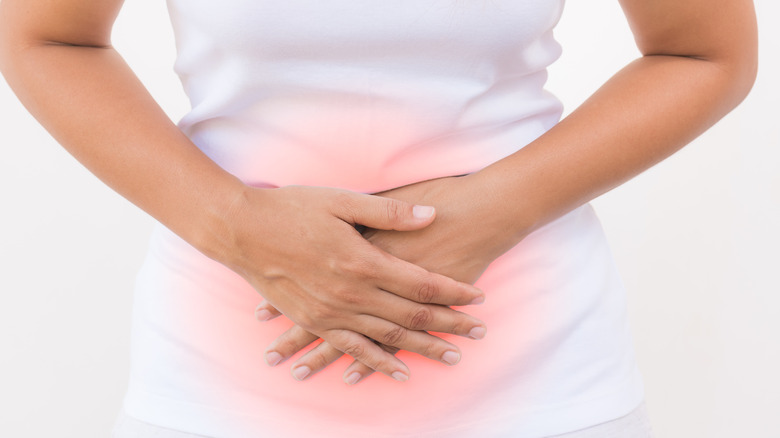 Person with nausea holding stomach 