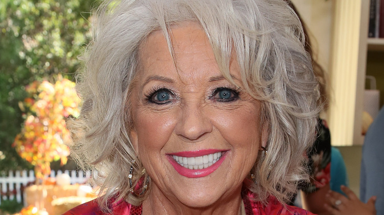 Paula Deen in pink vest smiling