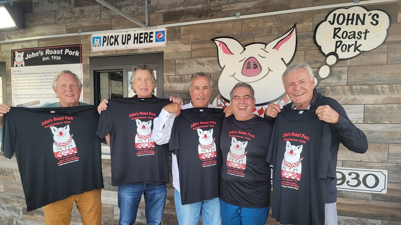 Men standing in front of John's Roast Pork pick-up window