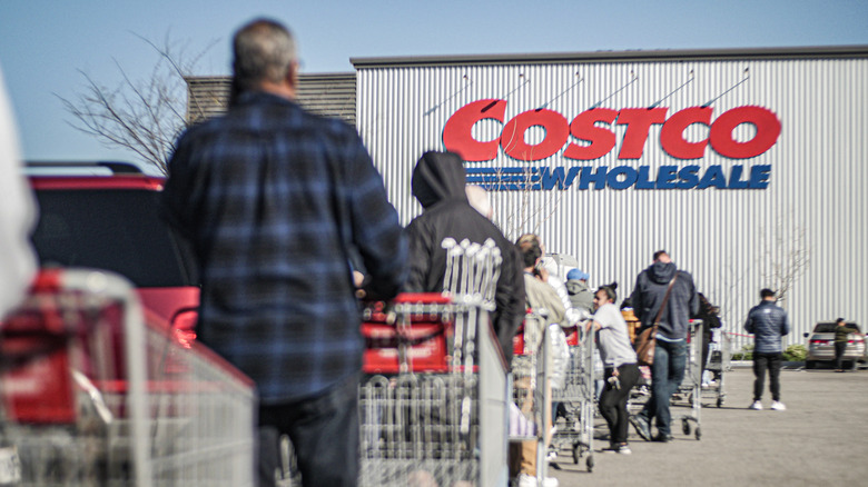 People with shopping carts waiting in line for Costco