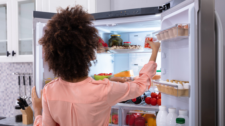 Person taking food from refrigerator