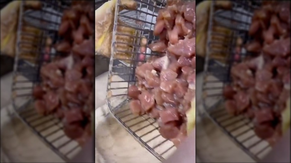 raw chicken being added to seasoned flour