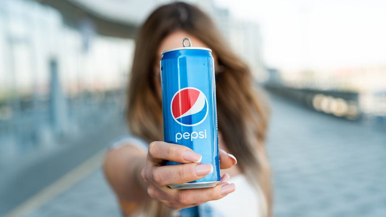 Woman holding can of Pepsi