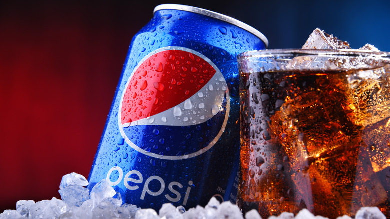 pepsi can next to iced glass of soda