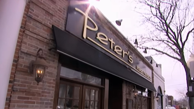 The brick exterior of a Peter's with a black awning.