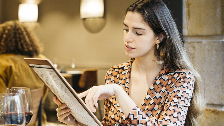 Woman pointing to restaurant menu