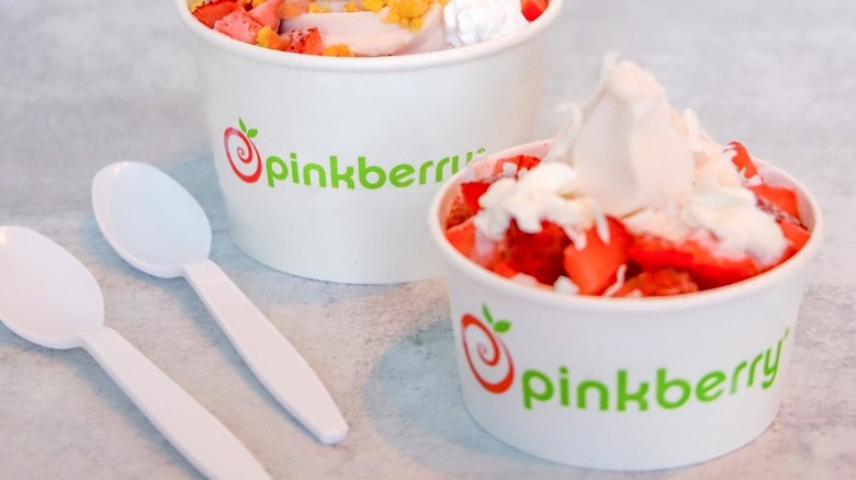 Two cups of Pinkberry frozen yogurt with fruit toppings