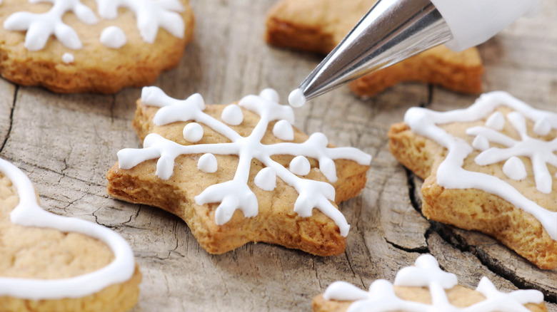 Piping royal icing on a cookie