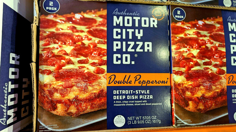 Motor City Pizza Co. boxes on grocery store shelf.