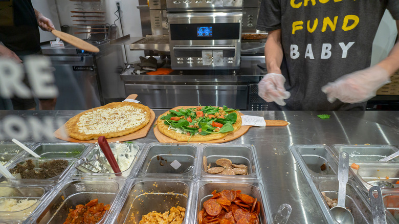 Employees making pizza at Oath Pizza