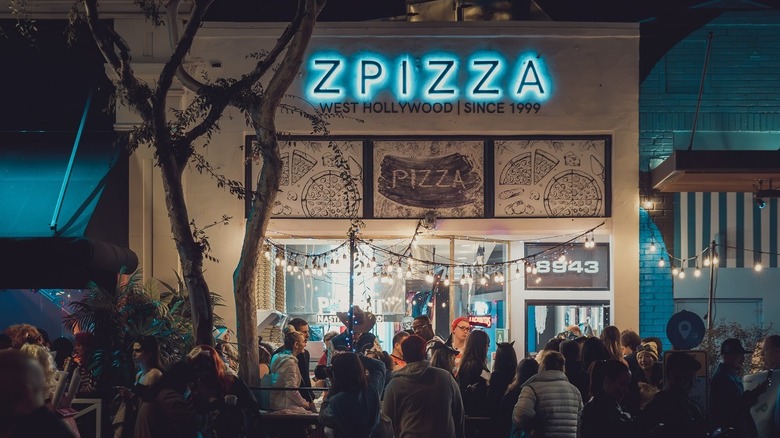 Exterior shot of a Zpizza in West Hollywood with a crowd of people outside