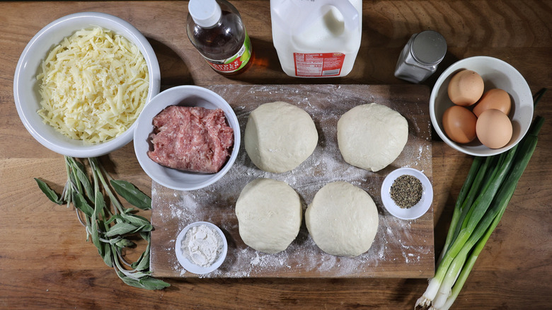 sausage gravy breakfast pizza ingredients laid out on cutting board