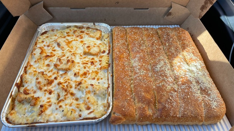 A tray of Pizza Hut's Creamy Alfredo Pasta and breadsticks.