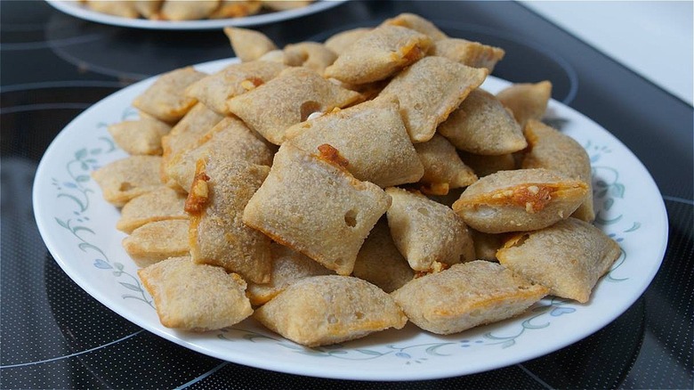 pizza rolls piled on a white plate