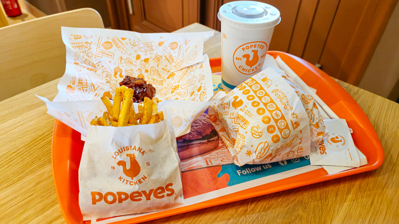 A tray of Popeyes food with fries and drink