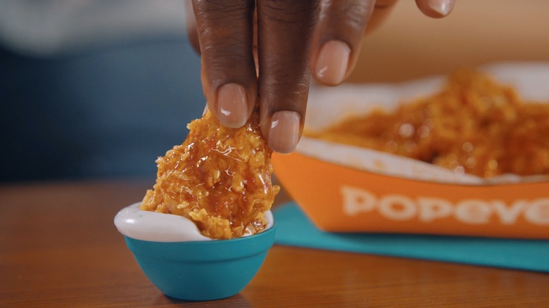 Dipping Popeyes wing in sauce
