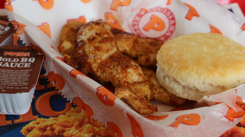 Closeup of Popeyes blackened chicken tenders and a biscuit