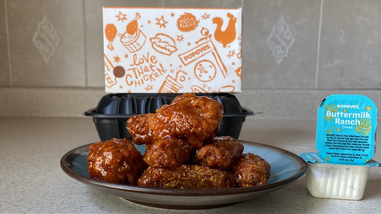 Popeye's wings on plate beside ranch sauces