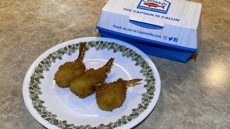 Captain D's butterfly shrimp on plate next to takeout box