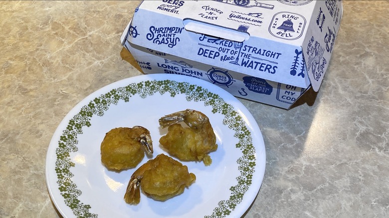 Long John Silver's battered shrimp on plate next to takeout container