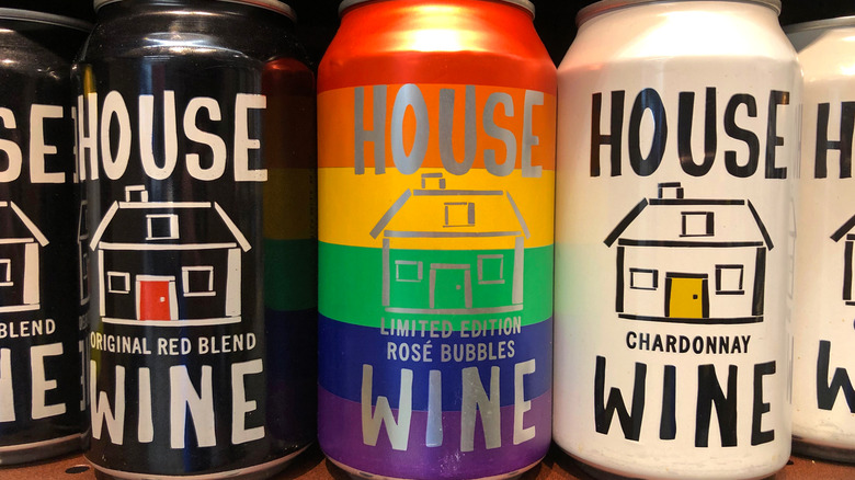 Grocery store shelf with cans of HOUSE brand Wines. Red, rose bubbles and chardonnay