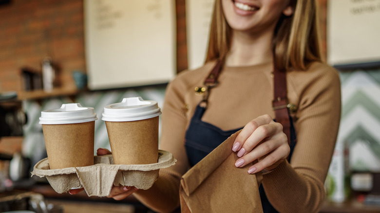 Barista with two coffees and food 