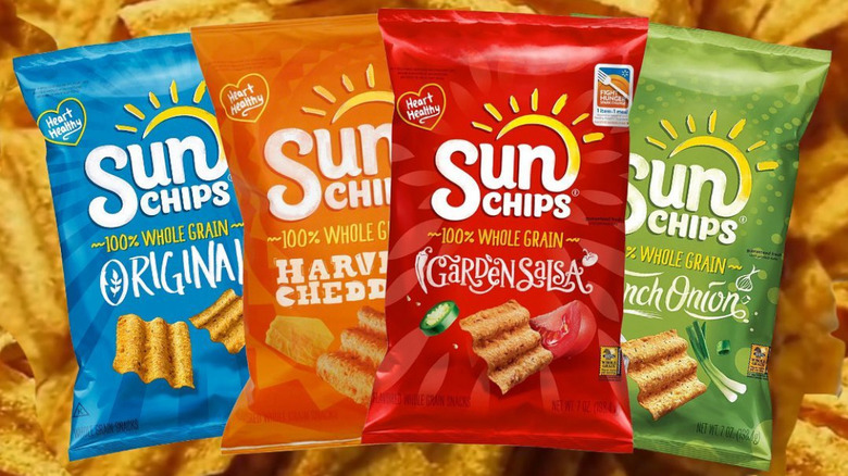 Bags of sun chips in front of a picture of the chips